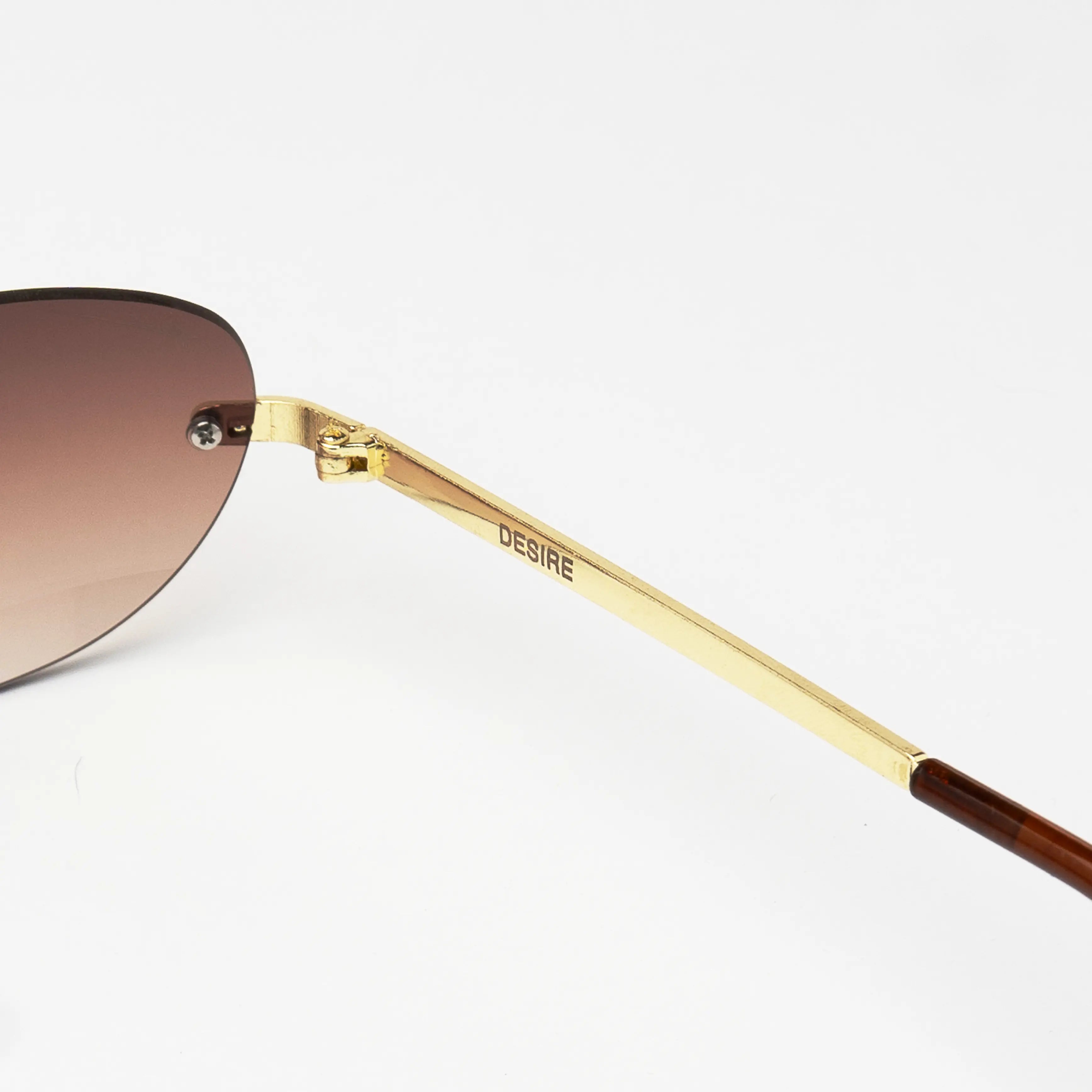 Desire Sugar Brown Sunglasses at a three-quarter angle highlighting the elegant oval shape and brown gradient lens.