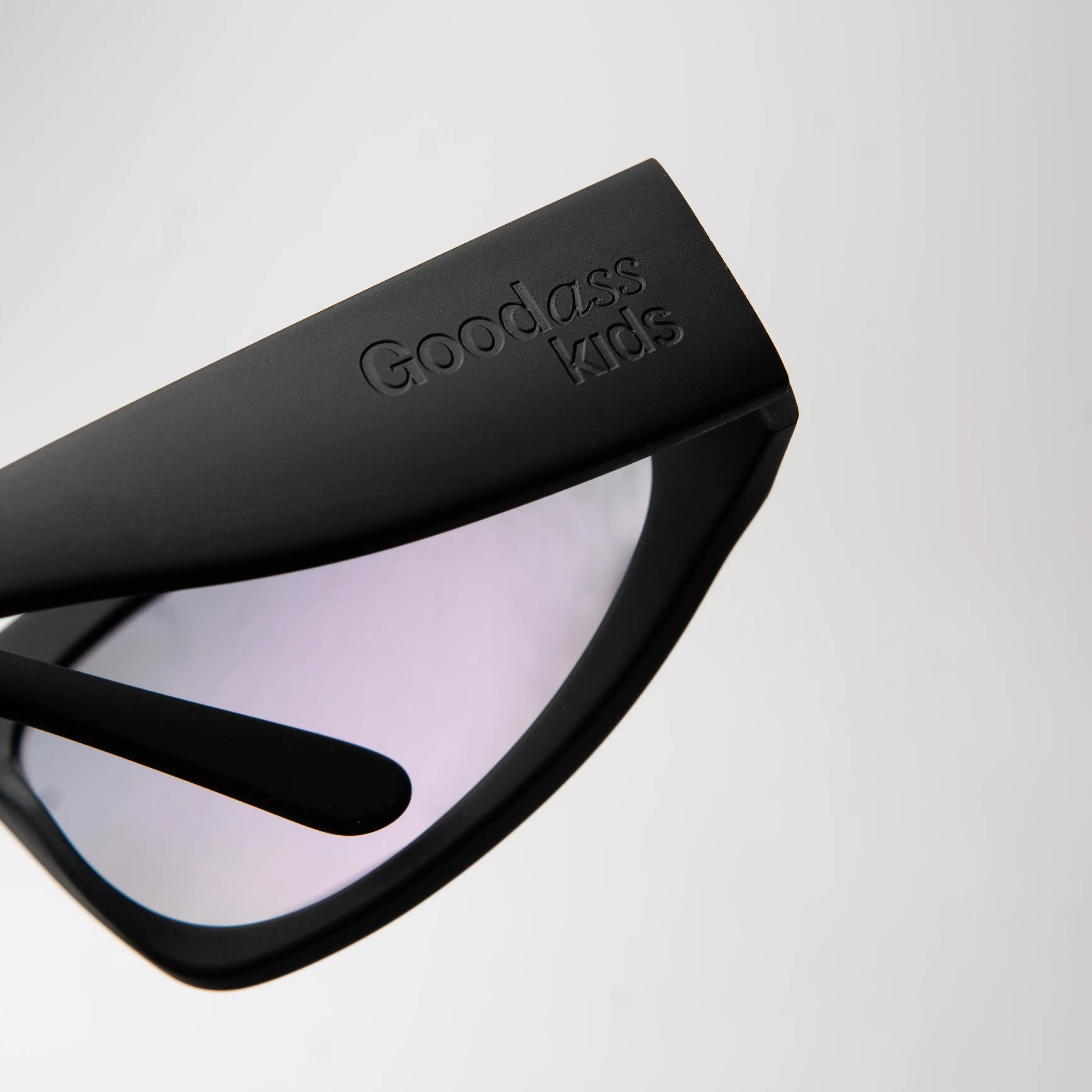 Icon Sakura Sunglasses with a close-up of the hinge detail on the black frame and pink polarized lens.