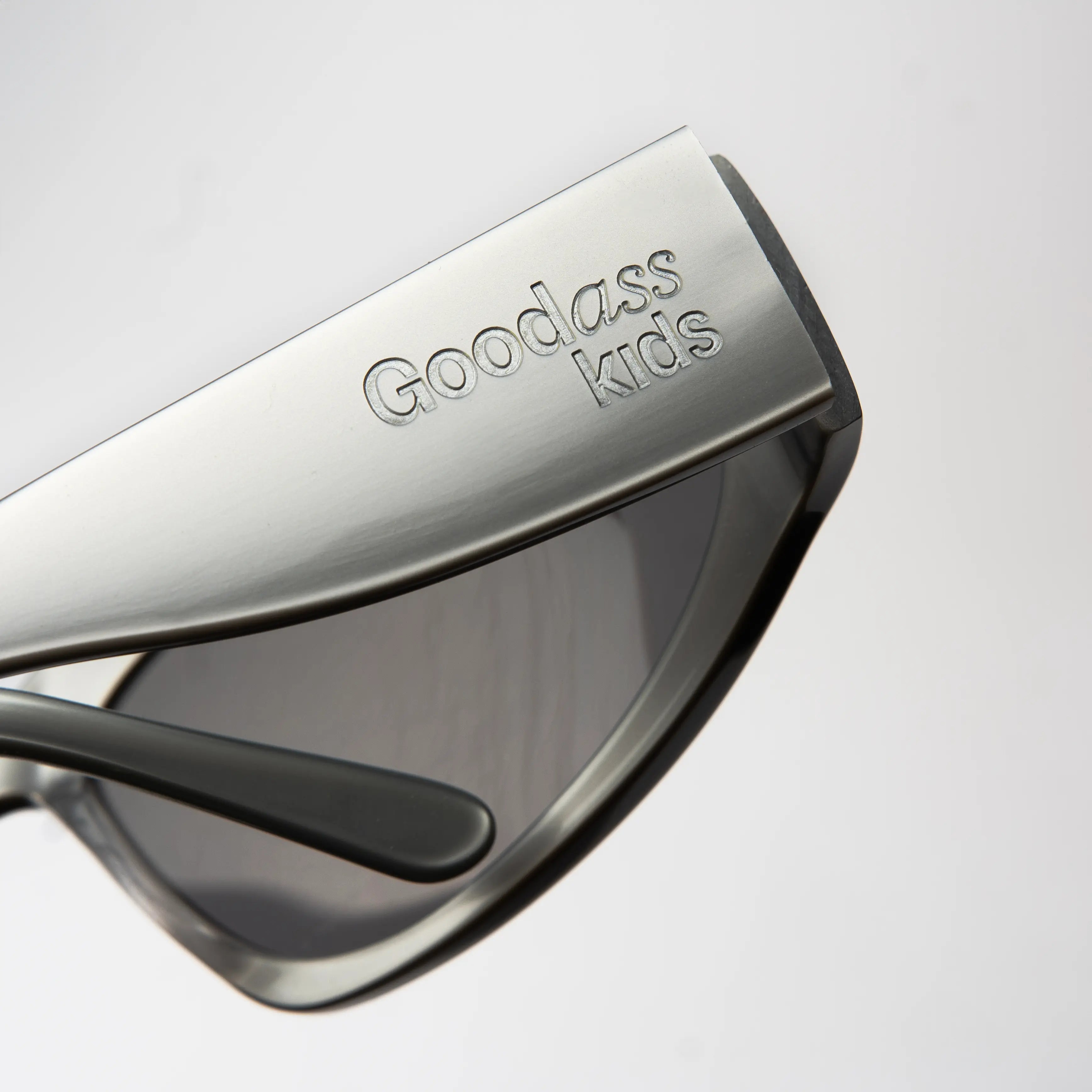 Icon Silver Sunglasses with a close-up of the hinge detail on the polished silver frame and smoke lens.