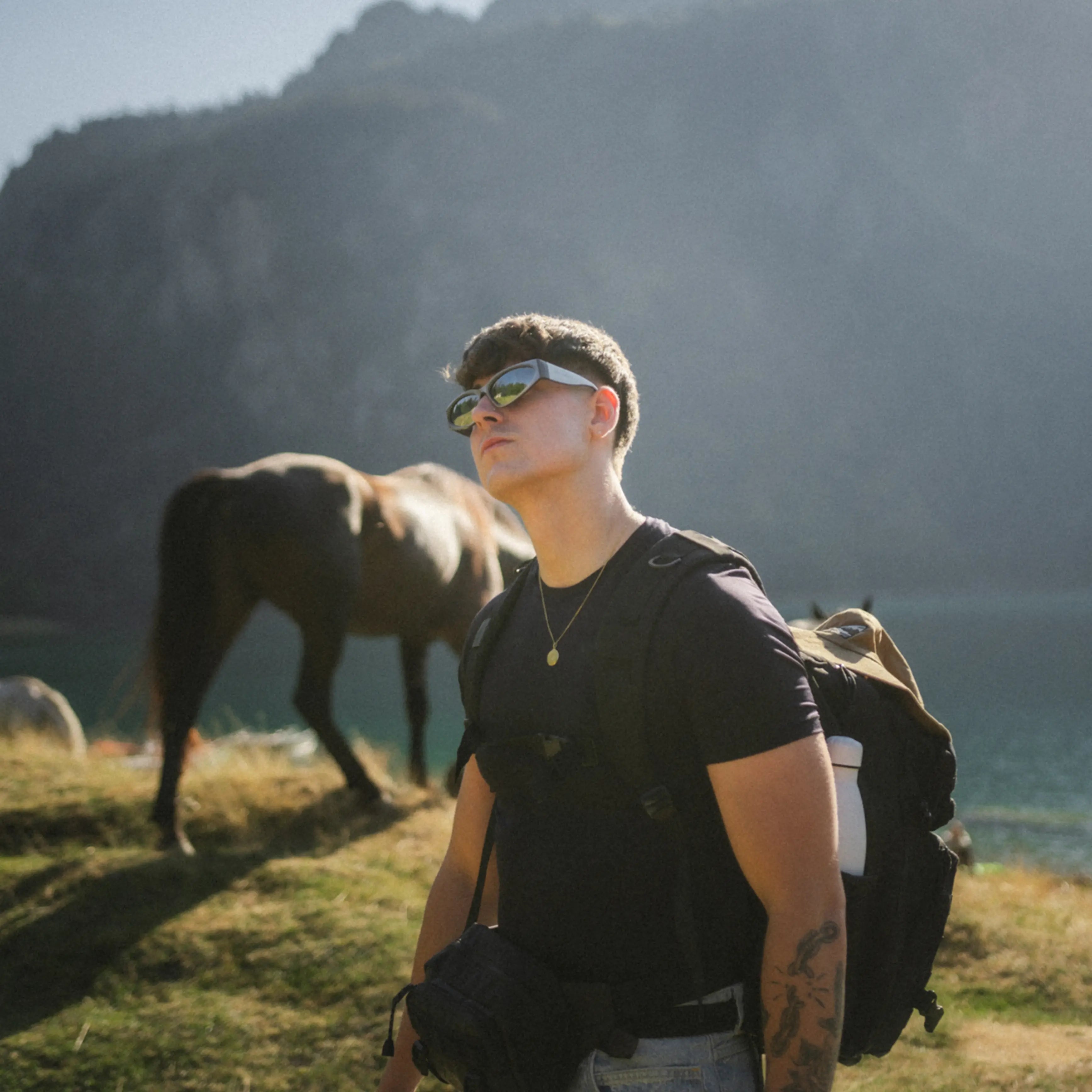 Model wearing Icon Silver Sunglasses outdoors, smoke polarized lenses and silver frame for effortless street style.